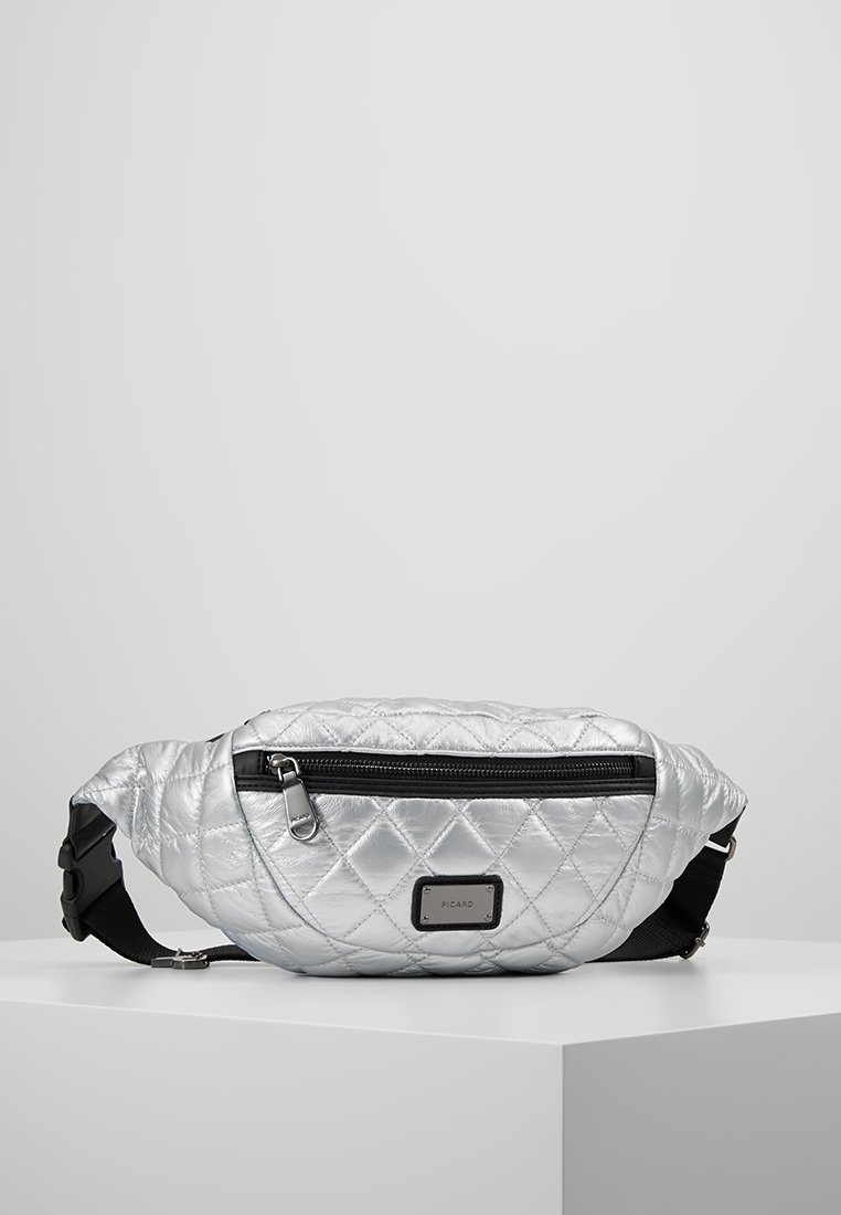 Sac banane matelassé argenté avec poche zippée noire, sangle noire réglable et petite étiquette de marque rectangulaire sur le devant.