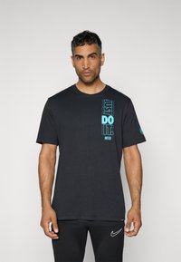Sort bomulds T-shirt med lodret blå tekst "JUST DO IT. INTER" på venstre side. Korte ærmer og rund hals.