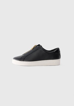 Sneaker in pelle nera a basso profilo con suola bianca e chiusura con zip dorata, vista laterale, stile minimalista su sfondo semplice.