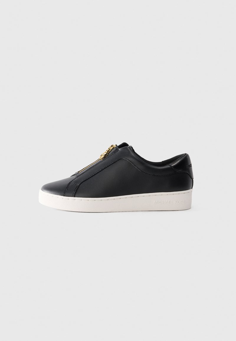 Svart lavt lær sneakers med hvit såle og gullglidelås, sidevisning, minimalistisk stil på ensfarget bakgrunn.
