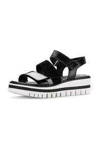 Schwarze Plattform-Sandalen mit zwei breiten Riemen; aus Wildleder und mit glänzender Oberfläche. Weiße und schwarze gestreifte Sohle mit strukturierten Rillen.