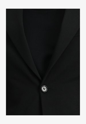 Zwarte blazer met een notch lapel, enkele, ronde zilveren knoopsluiting en een gestructureerde stof, gelaagd over een effen zwarte top.