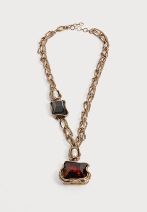 Collar de cadena en tono dorado con grandes piedras rojas y negras y dos cuentas similares a perlas enmarcadas en metales irregulares.