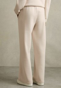 Helle rosa Sweatpants aus weichem Material. Mit einem geraden Bein Design und einer dezenten Gesäßtasche. Strukturierten Oberfläche, minimalistischer Stil.