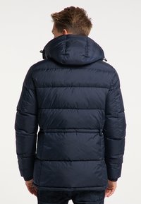 Granatowa pikowana kurtka puchowa z kapturem, posiadająca poziome przeszycia, elastyczne mankiety oraz ściągacz przy kołnierzu zapewniający dopasowanie.