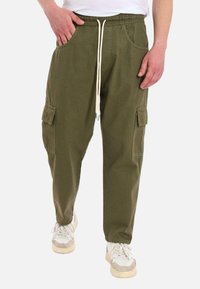 Pantaloni cargo verde oliva realizzati in cotone, dotati di una vita elasticizzata con lacci, tasche laterali e tasche cargo su entrambe le gambe.