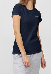 Navy blue short-sleeve t-shirt made from soft fabric. Features a small pink logo on the left chest area. Simple, fitted design.