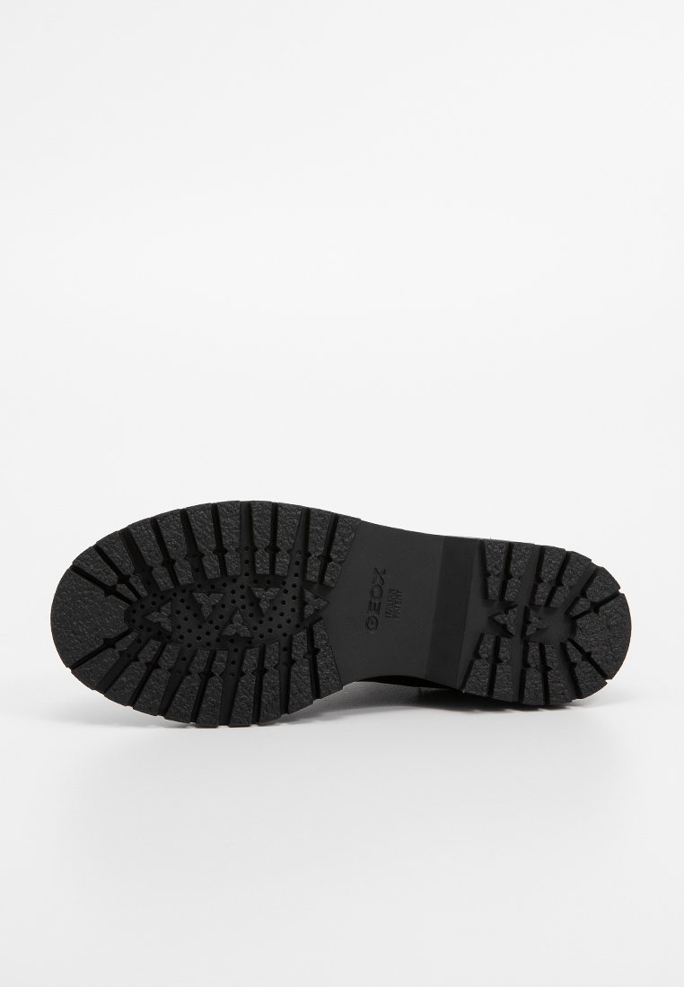 Semelle en caoutchouc noir avec des motifs de bande de roulement profonds et des trous de ventilation, marquée "GEOX" pour une traction et une durabilité.