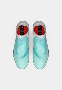 Pantofi sport de culoare albastru deschis cu un upper texturat, interior roșu și toc negru. Dispun de un logo Nike roz și un design aerodinamic.