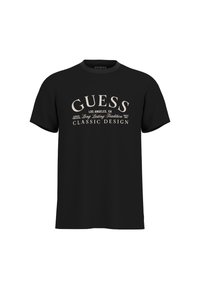 Camiseta negra con un destacado logo y texto en color claro "GUESS". Botones cortos y un diseño clásico de cuello redondo. Textura de tela suave.