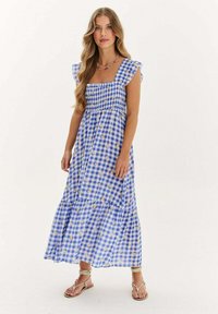 Modrá a biela gingham maxi šaty s volánovými rukávmi, elastickým živôtikom a vrstvenou sukňou. Obsahujú jemné kvetinové akcenty po celom obvode.