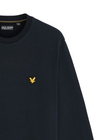 Donkerblauwe sweatshirt van katoen, met een ronde hals en een klein geel geborduurd arendlogo op de borst.