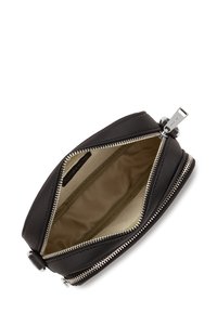 Borsa in pelle nera con hardware argentato, dotata di chiusura con zip e fodera in tessuto beige. L'interno presenta un scomparto e un'etichetta con logo discreto.