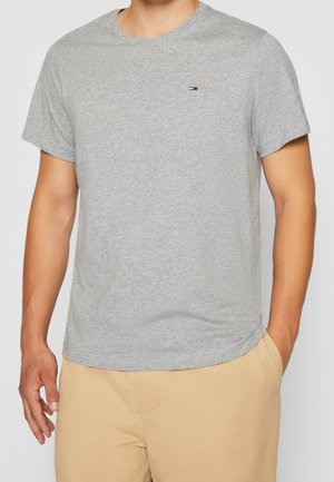 Graues Baumwoll-T-Shirt mit Rundhalsausschnitt, kurzen Ärmeln und einem kleinen gestickten Logo auf der linken Brust. Sanfte Textur, lässige Passform.