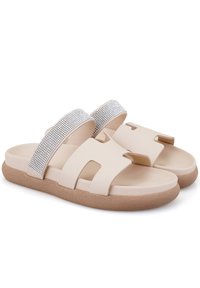 Sandales à glissière beiges avec deux larges sangles, dont une ornée de strass en argent. Semelle en mousse douce pour plus de confort.