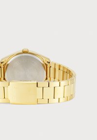 Montre Casio en doré avec un boîtier en acier inoxydable et un bracelet. Caractéristiques d'une finition polie, d'un cadran rectangulaire et d'une fermeture avec logo gravé.