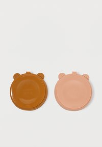 Δύο καπάκια σιλικόνης σε σχήμα αρκούδας: το ένα καφέ με στρογγυλά αυτιά, το άλλο ροζ. Και τα δύο διαθέτουν λεία υφή και κυκλικό σχέδιο.