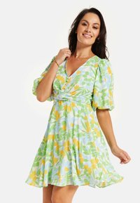 Floral dress featuring a v-neck, puff sleeves, and a fitted waist. Colors include light blue, yellow, and green botanical patterns.