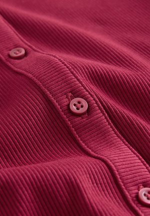 Cardigan burgundiu cu dungi, cu un rând de nasturi rotunzi roz, evidențiind textura și detaliile pe partea cu nasturi. Material moale, design casual.