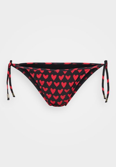Melna bikini apakša ar sarkano sirds rakstu. Iespējas regulējamas saitītes sānos ar mazām zeltītām detaļām. Gluda tekstūra.