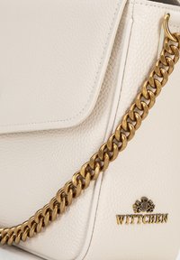 Borsa a mano in pelle bianca con finitura texture, dotata di una tracolla in catena dorata e di un logo dorato sul davanti.