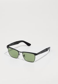 Ochelari de soare negri cu lentile verzi, formă rectangulară, cadru din metal și plastic, dotat cu accesorii argintii și branding subtil pe brațele ochelarilor.