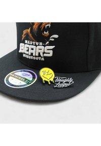 Musta baseball lippalakki, jossa on brodeerattu karhulogo, teksti "MASTUR BEARS MINNESOTA" sekä kaksi nappia: keltainen tippadesign ja musta "Naughty League" logo.