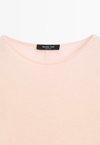 Helles rosa Rundhals-Shirt mit einem schwarzen Massimo Dutti-Label, das in den Kragen genäht ist, auf einem weißen Hintergrund präsentiert.
