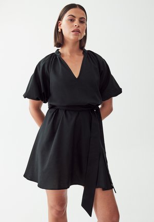Black dress with a V-neck, short puff sleeves, a cinched waist, and a tie belt. The fabric has a smooth texture and a flowy design.