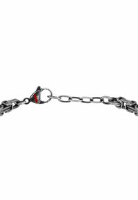 Bracciale in argento con maglie intrecciate. Presenta un gancio a moschettone con un accento rosso. Superficie metallica texture.