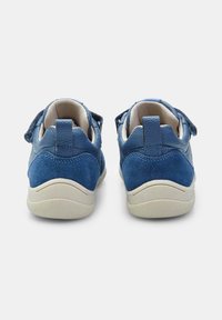 Blå sneakers med en kombination av släta och mockaskinn-texturer, med kardborreband, en vadderad krage och en vit gummisula.