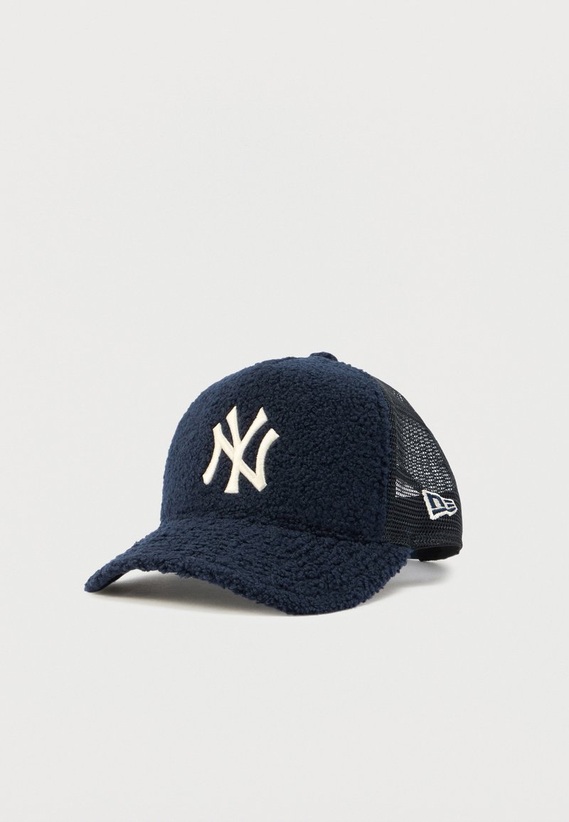 Tamnoplava mekana kapa s bijelim izvezenim logotipom "NY". Ima zakrivljeni sjenilo i crnu mrežastu pozadinu za ventilaciju. Uključena je podesiva traka.