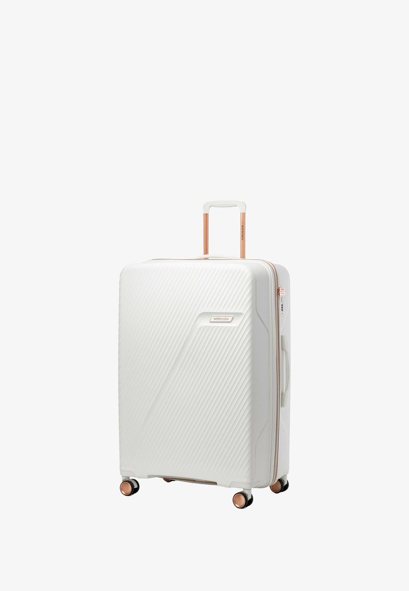 Maleta rígida blanca con textura en ribetes diagonales, acabados en oro rosa, asa telescópica y cuatro ruedas multidireccionales.