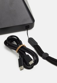 Black USB cable with textured grip, triangular black connector housing, and a secured elastic band. Includes branded strap and hardware details.