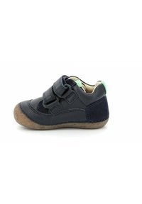 Zapato de piel azul marino con dos correas de Velcro, parte superior texturizada y suela de goma marrón. Forro suave y detalle acentuado en verde en la parte trasera.