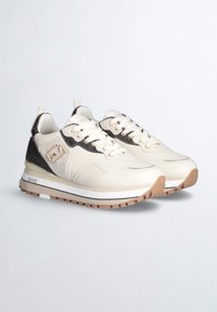 Sneaker beige chiaro con tomaia testurizzata, dettagli marroni, accessori dorati e pannello laterale a fantasia. Presenta una suola spessa in gomma.