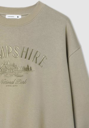 Oliwkowy sweter z prążkowanym okrągłym dekoltem, z tłoczonym napisem "HAMPSHIRE" oraz grafiką domu i drzew.