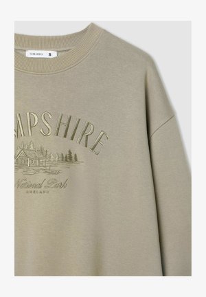 Oliwkowy sweter z prążkowanym okrągłym dekoltem, z tłoczonym napisem "HAMPSHIRE" oraz grafiką domu i drzew.