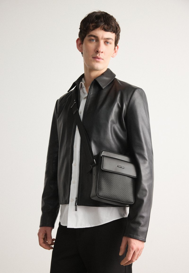 Calvin Klein VERTICAL LINES REPORTER S MONO - Cross body bag - black ...
