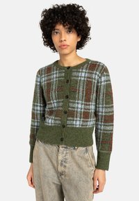 Zöld kockás kardigán kék és piros mintákkal, gombos elülső résszel, bordázott mandzsettákkal és aljjal, texturált kötött anyagból készült.