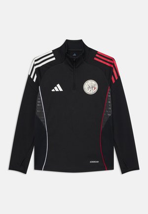 Črn dolg rokav športna majica s pol-zadrgo, z rdečimi in belimi črtami na ramenih, logotipom na prsih in zračnimi stranskimi paneli.