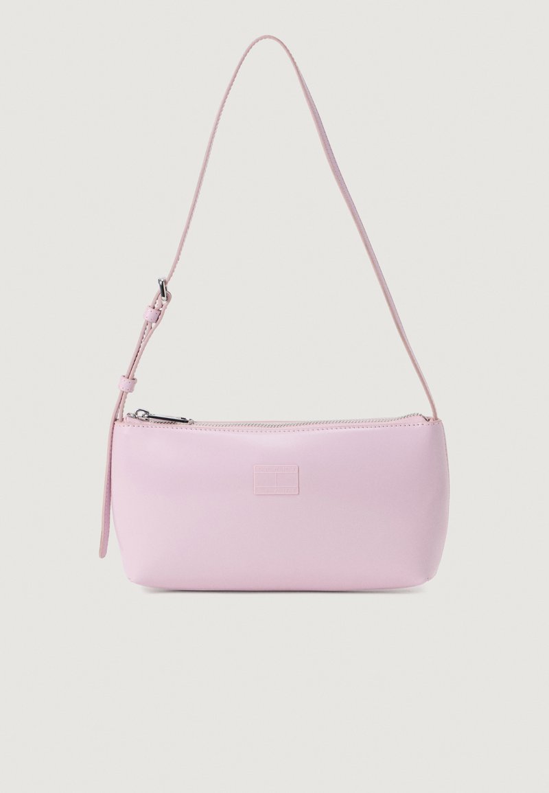 Różowa skórzana torebka o gładkiej teksturze, owalnym kształcie, długim regulowanym pasku i zapięciu na zamek. Posiada wytłoczone logo marki z przodu.