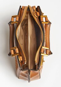 Sac à main en cuir marron avec quincaillerie dorée, fermetures à glissière doubles, et un intérieur à deux compartiments doté d'une doublure en tissu beige avec un motif de logo.