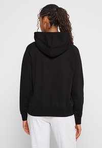 Czarna bluza z kapturem, wykonana z miękkiego materiału, z kapturem na sznurki, ściągaczami na rękawach i luźnym krojem. Brak widocznych logo lub wzorów.