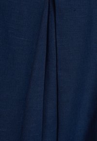 Tela texturizada de color azul oscuro con un pliegue vertical que recorre el centro.