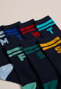 Paket šestih mornarskih nogavic z obarvanimi trakovi in črkami. Vsaka nogavica ima različno barvo prstov in črko dneva v tednu.