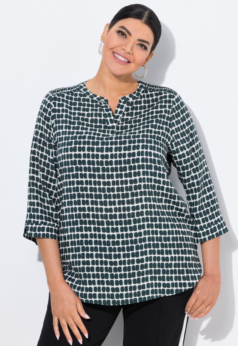 Groene en witte geblokte blouse, met een notch halslijn, 3/4 mouwen en een losse pasvorm. De stof heeft een gladde textuur met een geometrisch patroon.
