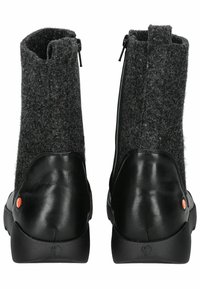 Botas de tobillo de cuero negro y fieltro gris con cremalleras laterales, texturas contrastantes y un acento redondo cerca del talón.