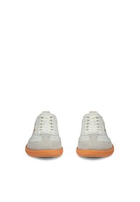 Pari valkoisia ja vaaleanharmaita lenkkareita, joissa oranssit kumipohjat, kuvattuna edestä valkoista taustaa vasten.