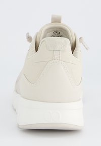 Baskets beiges avec une finition lisse et texturée. Comprend un col rembourré, des lacets élastiques et une semelle en caoutchouc blanche. Branding discret au niveau du talon.